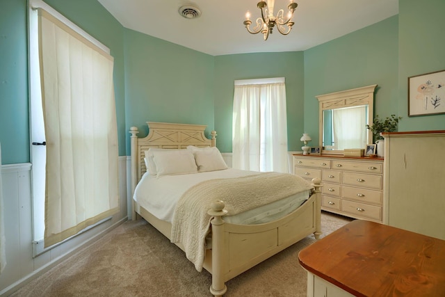 carpeted bedroom with an inviting chandelier