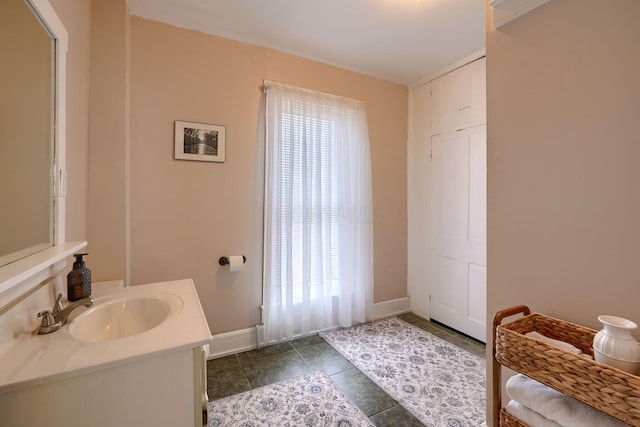 bathroom with tile patterned flooring, vanity, and a healthy amount of sunlight