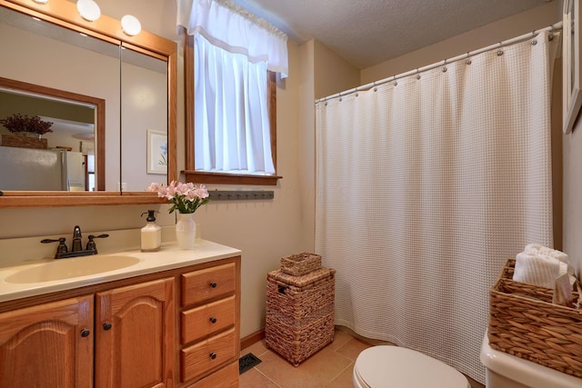 bathroom featuring tile patterned floors, vanity, toilet, and a textured ceiling