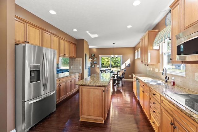 kitchen with pendant lighting, a center island, stainless steel appliances, and dark hardwood / wood-style floors