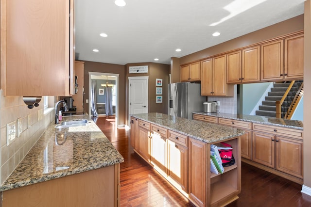 kitchen featuring decorative backsplash, sink, stainless steel fridge with ice dispenser, dark hardwood / wood-style floors, and a kitchen island