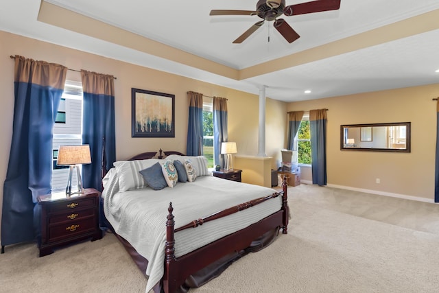 carpeted bedroom featuring ceiling fan, decorative columns, and multiple windows