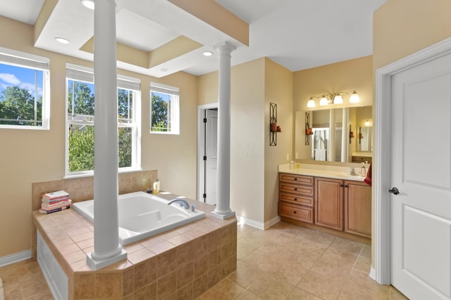 bathroom with decorative columns, tiled tub, plenty of natural light, and vanity