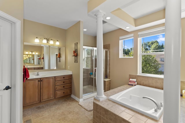 bathroom featuring tile patterned floors, vanity, ornate columns, and shower with separate bathtub