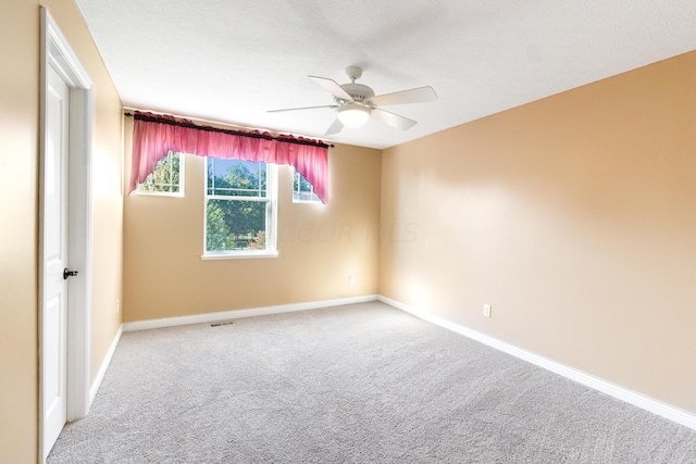 carpeted spare room with ceiling fan and a textured ceiling