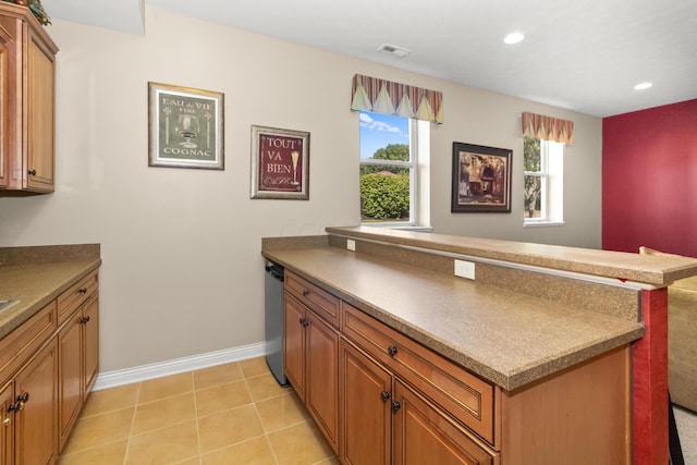 kitchen with stainless steel dishwasher, light tile patterned floors, and kitchen peninsula