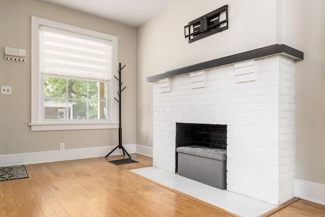 unfurnished living room with a fireplace and light hardwood / wood-style floors