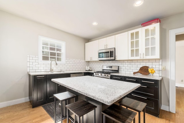 kitchen with a kitchen breakfast bar, a center island, sink, and appliances with stainless steel finishes