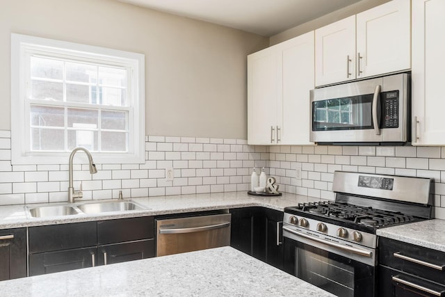 kitchen with white cabinets, backsplash, sink, and appliances with stainless steel finishes