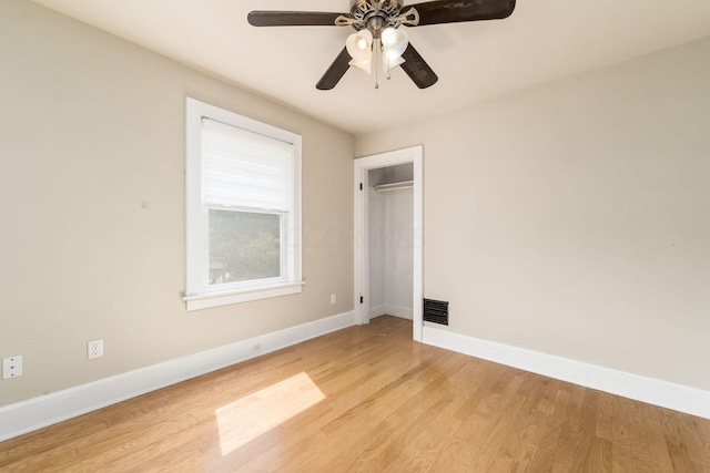 empty room with ceiling fan and light hardwood / wood-style flooring