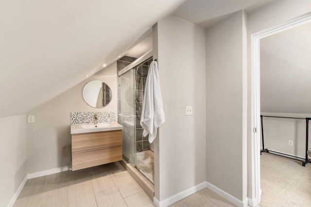 bathroom featuring vanity, vaulted ceiling, and an enclosed shower