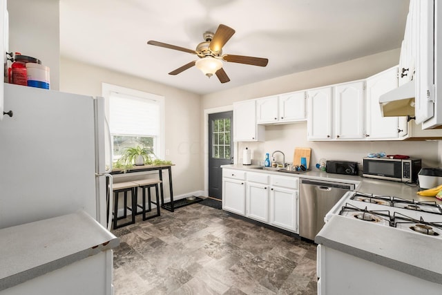 kitchen featuring white cabinets, stainless steel appliances, ceiling fan, and sink