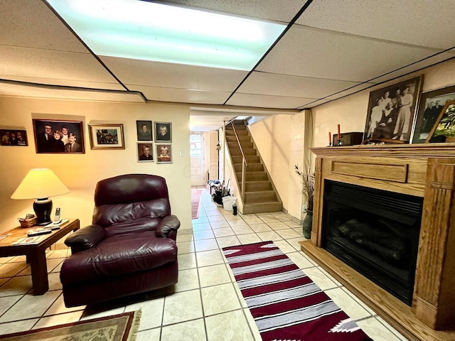 tiled living room featuring a paneled ceiling