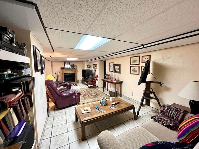 living room featuring a drop ceiling and light tile patterned flooring