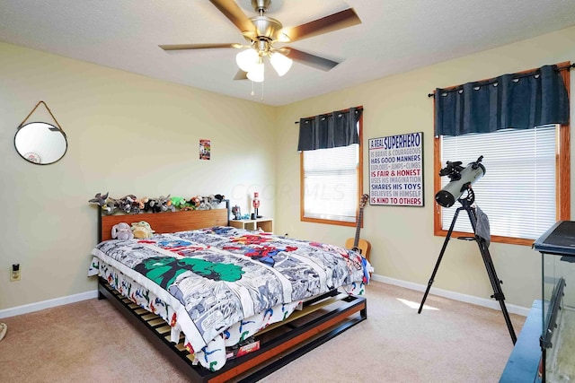 carpeted bedroom with ceiling fan and a textured ceiling