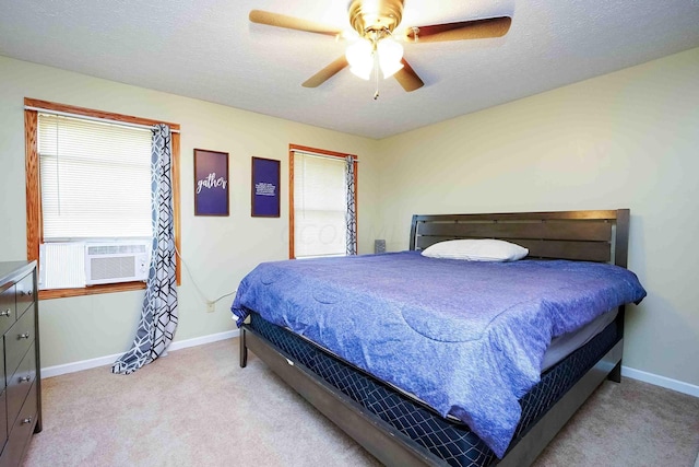 carpeted bedroom featuring multiple windows, a textured ceiling, ceiling fan, and cooling unit