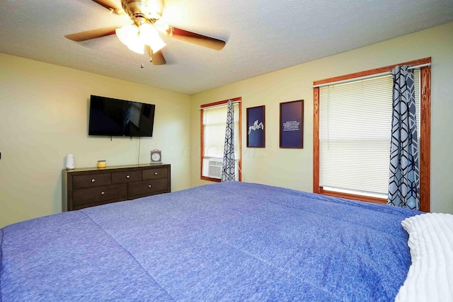 bedroom with ceiling fan and a textured ceiling