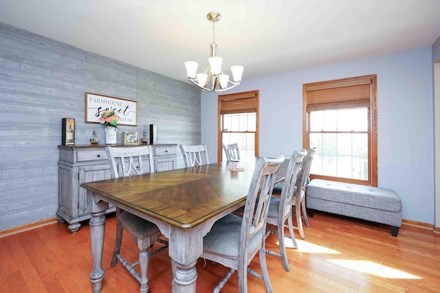 dining area featuring light wood-type flooring and an inviting chandelier