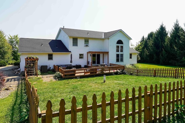 rear view of property with a lawn, a deck, and central AC