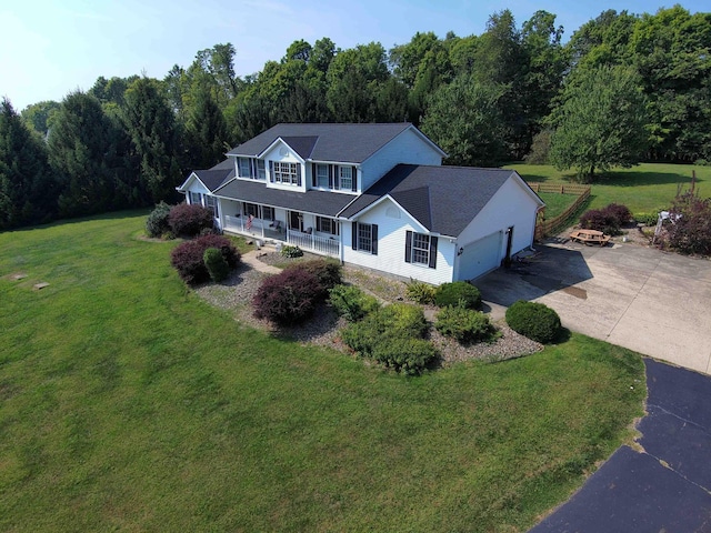 view of front of property with covered porch, a front yard, and a garage