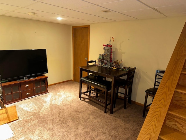 carpeted dining space featuring a drop ceiling