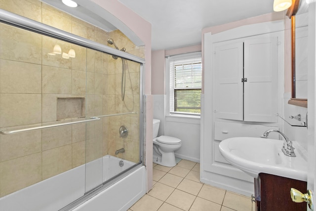 full bathroom featuring toilet, tile patterned flooring, vanity, and combined bath / shower with glass door