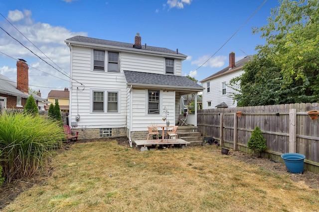 rear view of house featuring a deck and a lawn