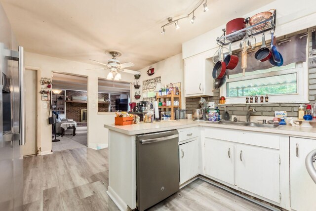 kitchen with dishwasher, white cabinetry, sink, and kitchen peninsula