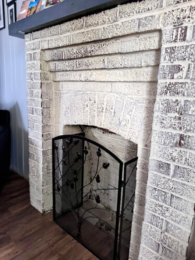 interior details with a brick fireplace and hardwood / wood-style flooring