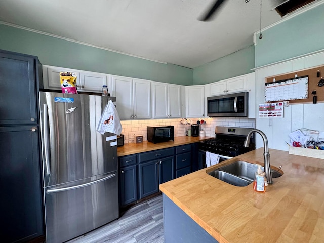 kitchen featuring blue cabinetry, white cabinetry, sink, and stainless steel appliances