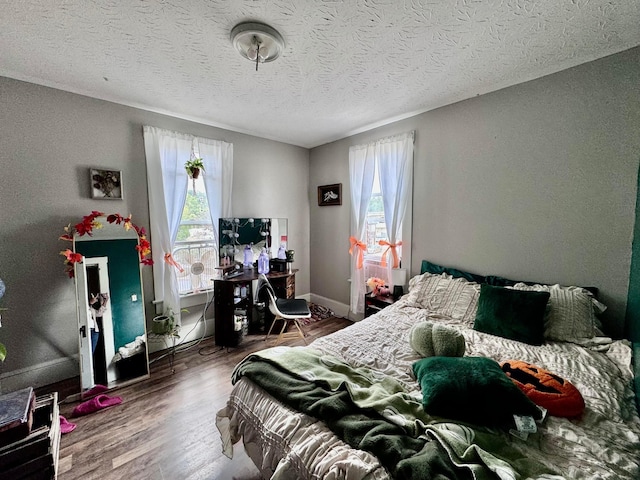 bedroom with a textured ceiling and dark wood-type flooring