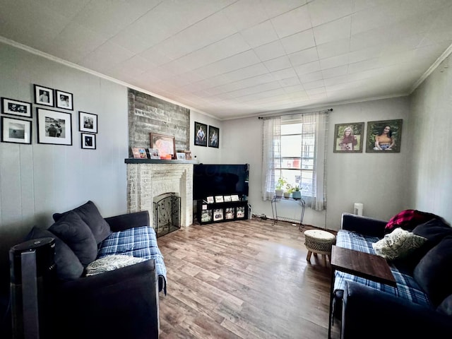 living room featuring crown molding, wood-type flooring, and a brick fireplace