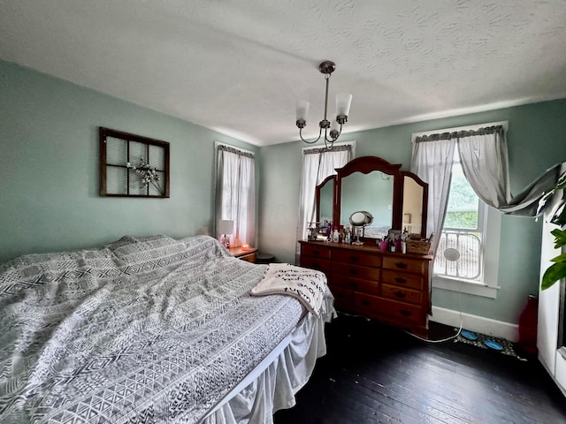 bedroom featuring a chandelier, a textured ceiling, and dark hardwood / wood-style floors