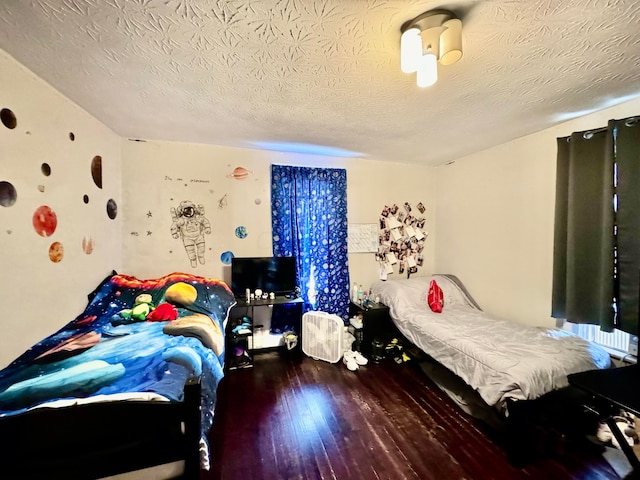 bedroom featuring dark hardwood / wood-style floors and a textured ceiling