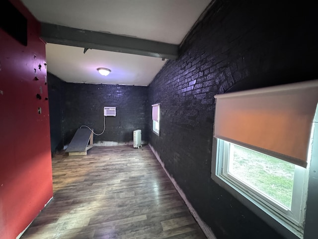 hallway with hardwood / wood-style floors, lofted ceiling with beams, and a wall mounted air conditioner