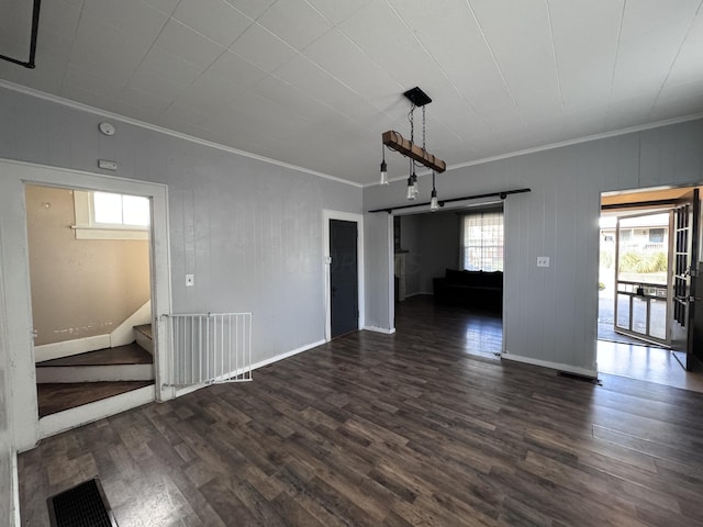 empty room featuring dark hardwood / wood-style floors, crown molding, and a healthy amount of sunlight