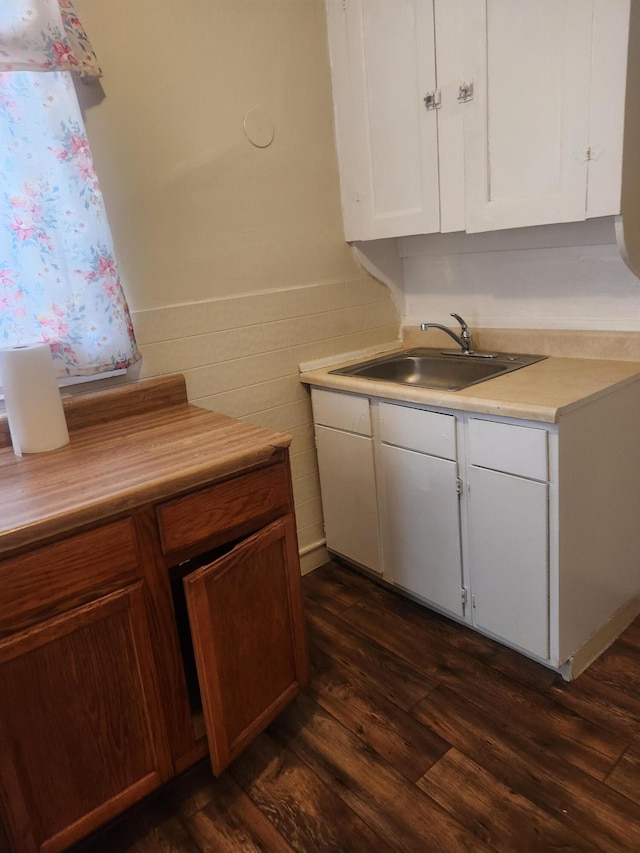 kitchen with tile walls, dark wood-type flooring, sink, and white cabinetry