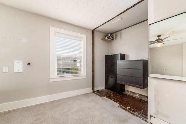 interior space featuring carpet flooring, ceiling fan, and a textured ceiling