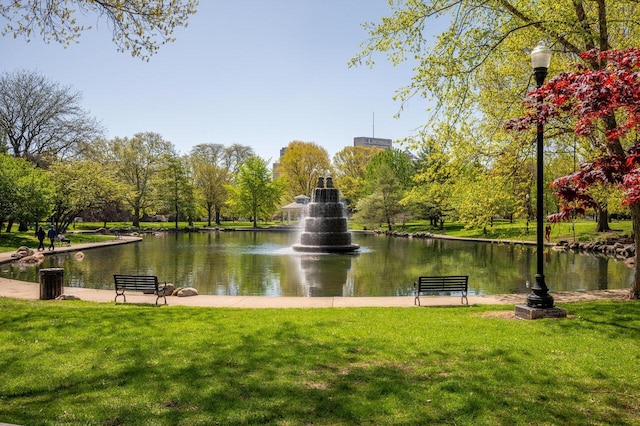 view of community featuring a lawn and a water view