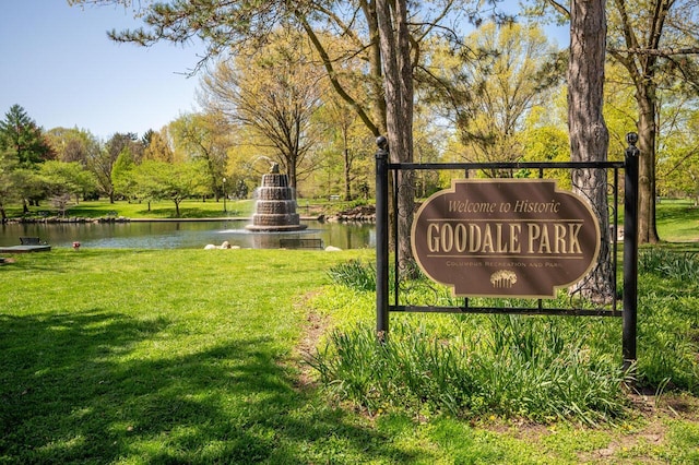 community sign featuring a yard and a water view