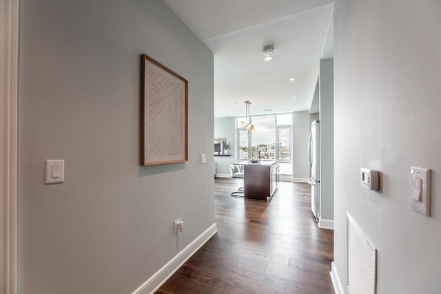 hall with dark hardwood / wood-style flooring and a notable chandelier