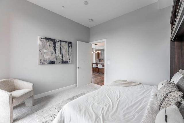 carpeted bedroom featuring an inviting chandelier