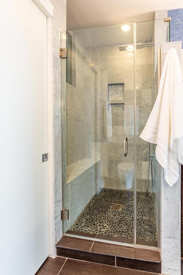 bathroom with a shower with door and tile patterned flooring