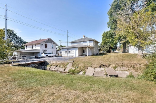 702 Coshocton Ave, Mount Vernon, OH 43050 - back of house with an attached garage and a lawn