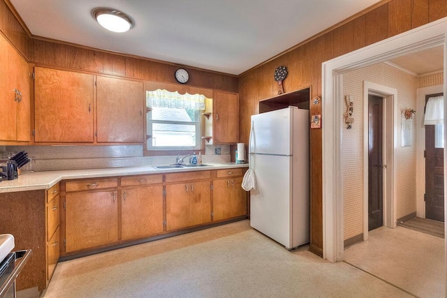 702 Coshocton Ave, Mount Vernon, OH 43050 - kitchen featuring freestanding refrigerator, light countertops, brown cabinets, ornamental molding, and stove
