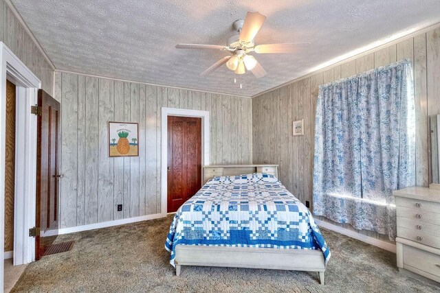 702 Coshocton Ave, Mount Vernon, OH 43050 - carpeted bedroom with a textured ceiling, wooden walls, and a ceiling fan