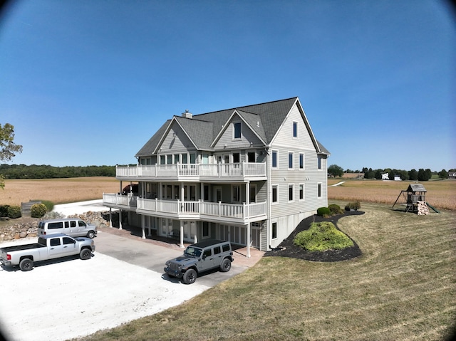 exterior space featuring a lawn and a balcony