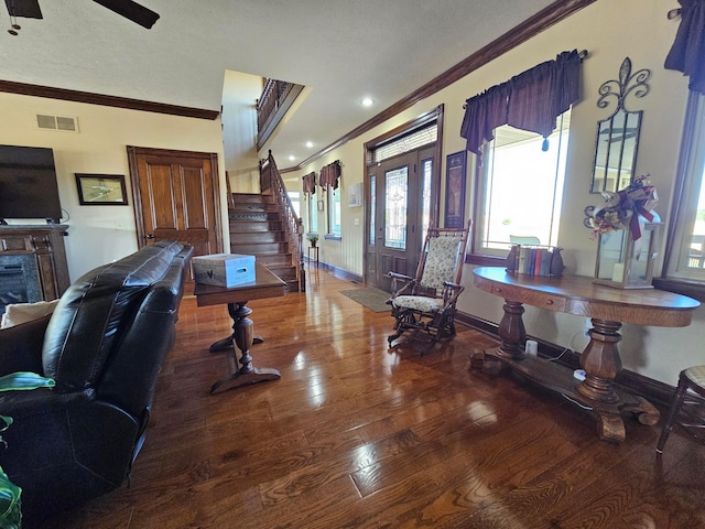 entrance foyer with a textured ceiling, ceiling fan, wood-type flooring, and crown molding