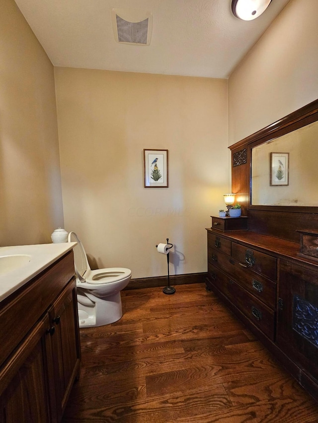 bathroom featuring vanity, wood-type flooring, and toilet