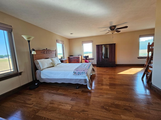 bedroom featuring a textured ceiling, dark hardwood / wood-style flooring, and ceiling fan